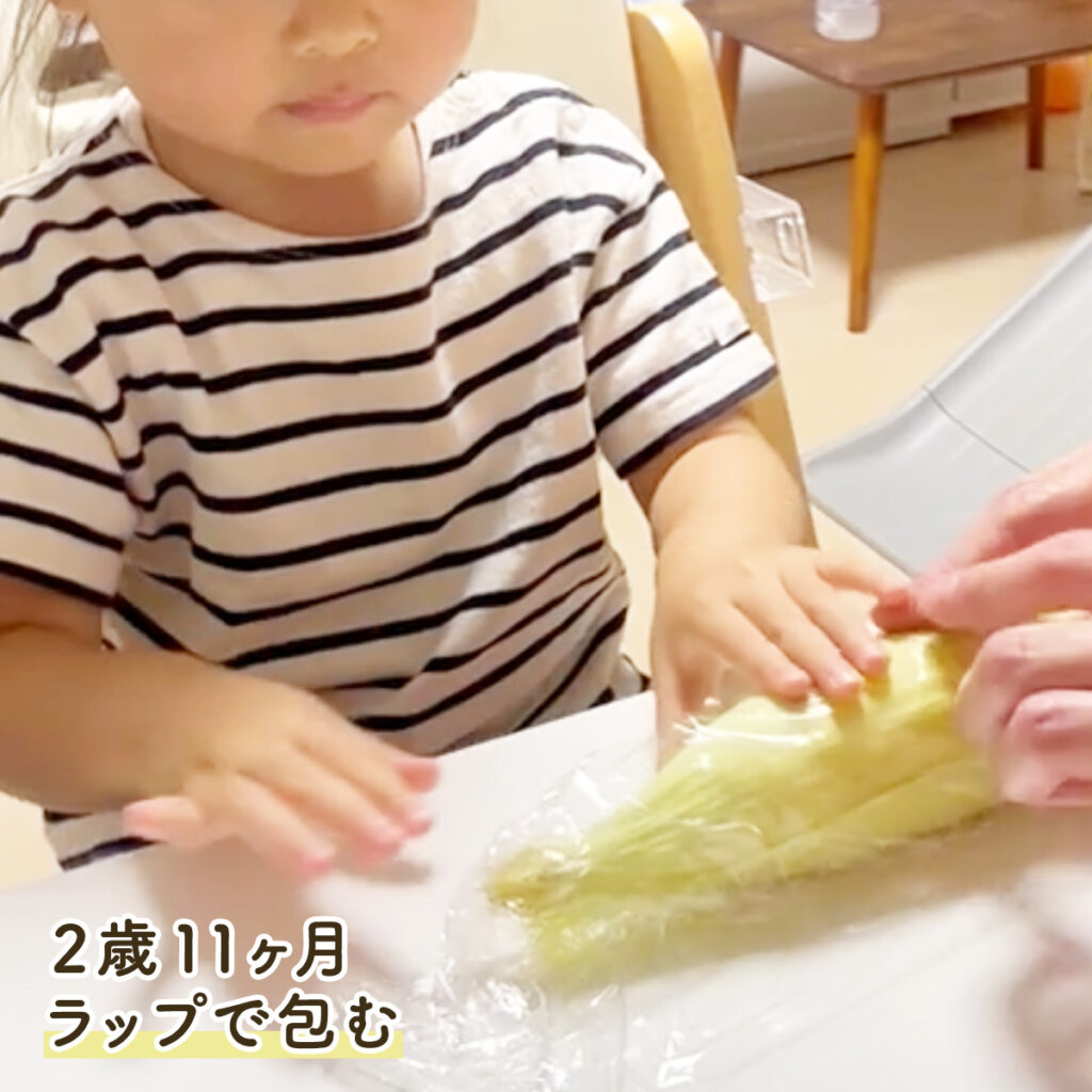 2歳11ヶ月 とうもろこしをラップで包むお手伝いの様子